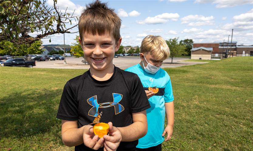 Students smile while releasing butterflies outside